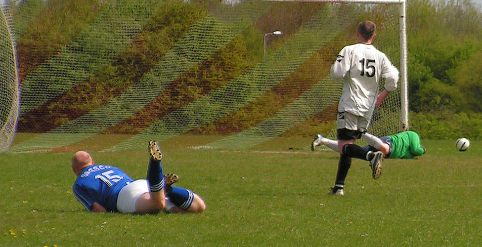 Muers, sprawled on the floor, sees his shot parried by the Arms goalkeeper.